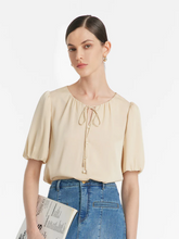 a lady in a beige mulberry silk puff sleeves blouse